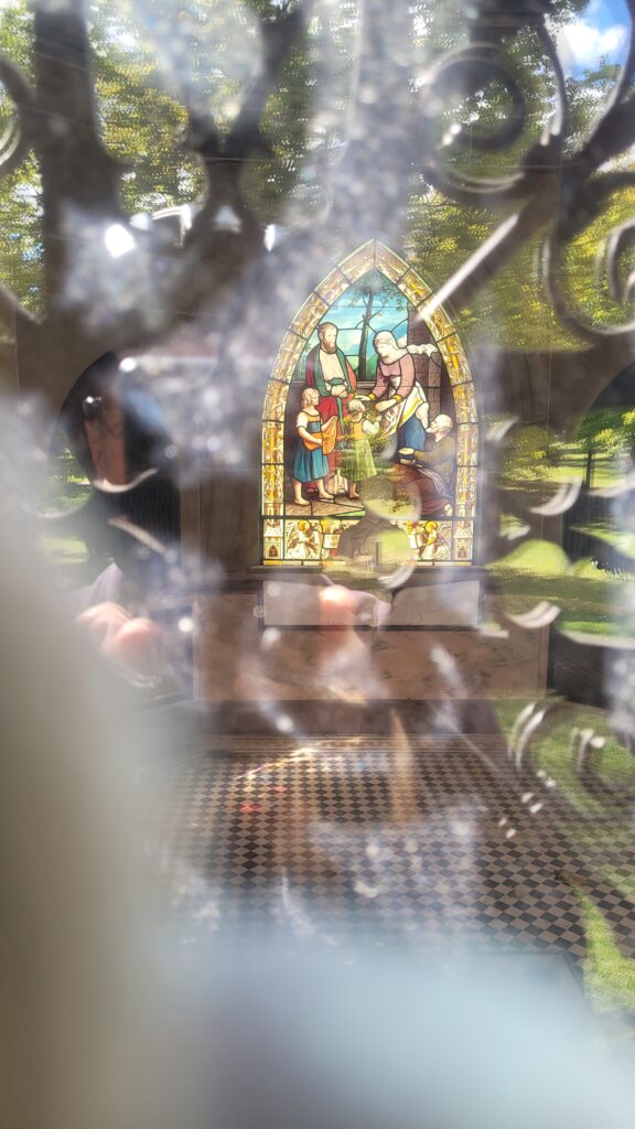 Peeking through the ornate, solid bronze gates and delicate floral motifs, one can view the richly decorated interior, which holds a marble bust of Tommy and the reliquaries with his parents' remains. 