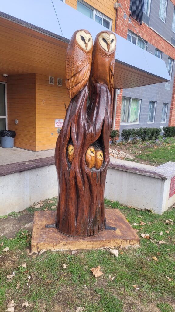 Owl family tree trunk sculpture.