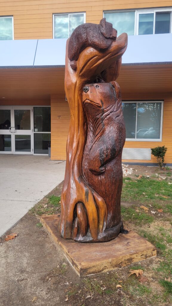 Bear family tree trunk sculpture.