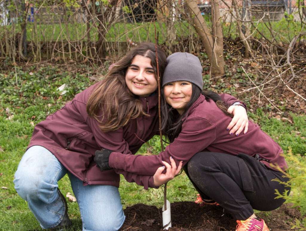 Two young women planting a tree. (Photo credit: ReForest London)