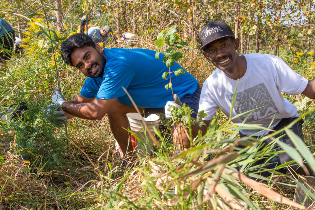 Two young men planting trees. (Photo credit: ReForest London)