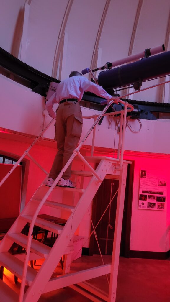 Man looking through a telescope at the night sky.