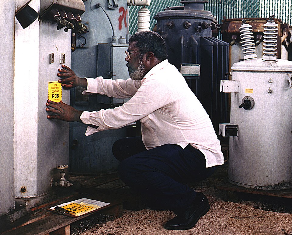 Man affixing a warning label on a transformer.