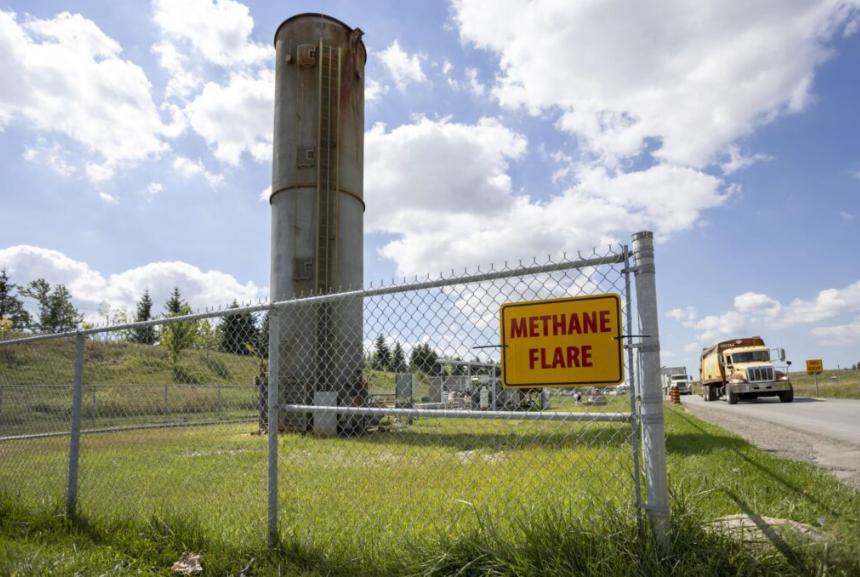 Methane flare warning sign in front of the smokestack where methane is burned off.