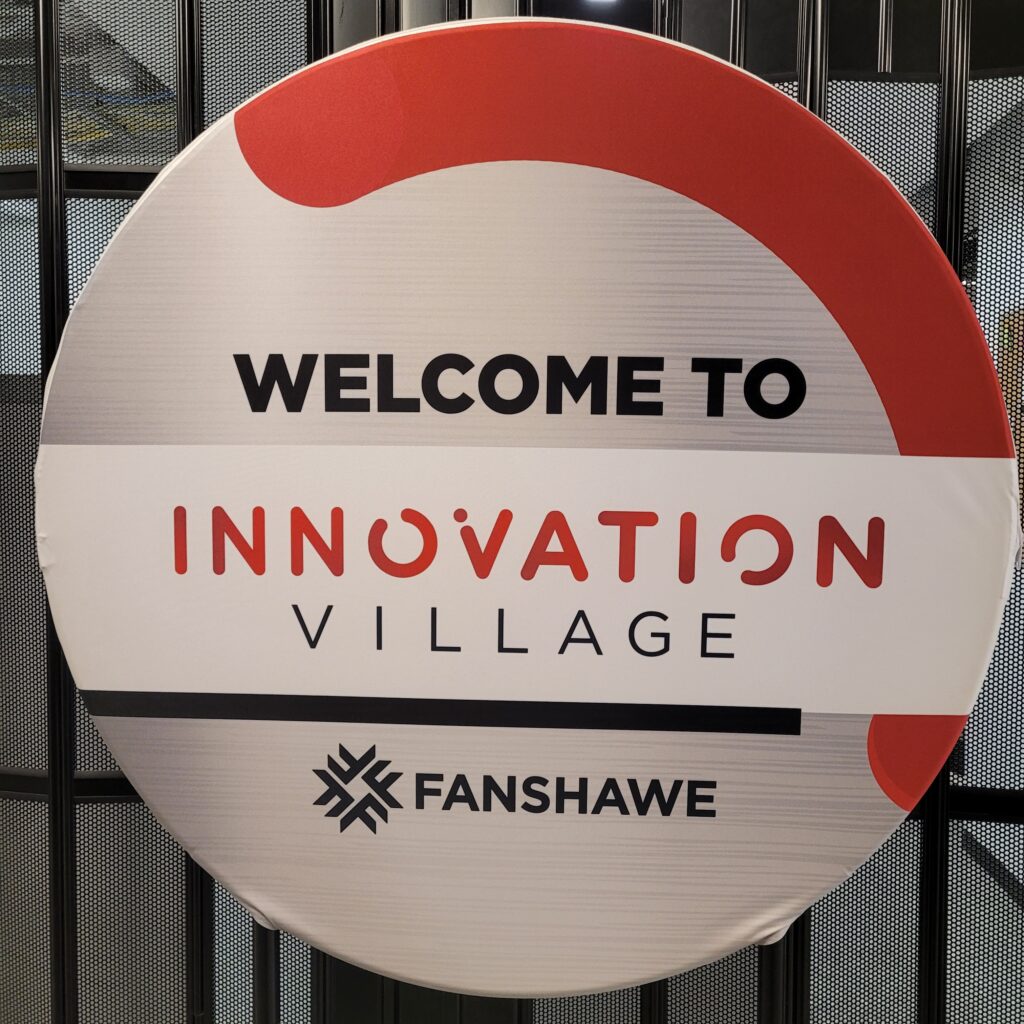 Circular sign - "Welcome to Innovation Village" Fanshawe.