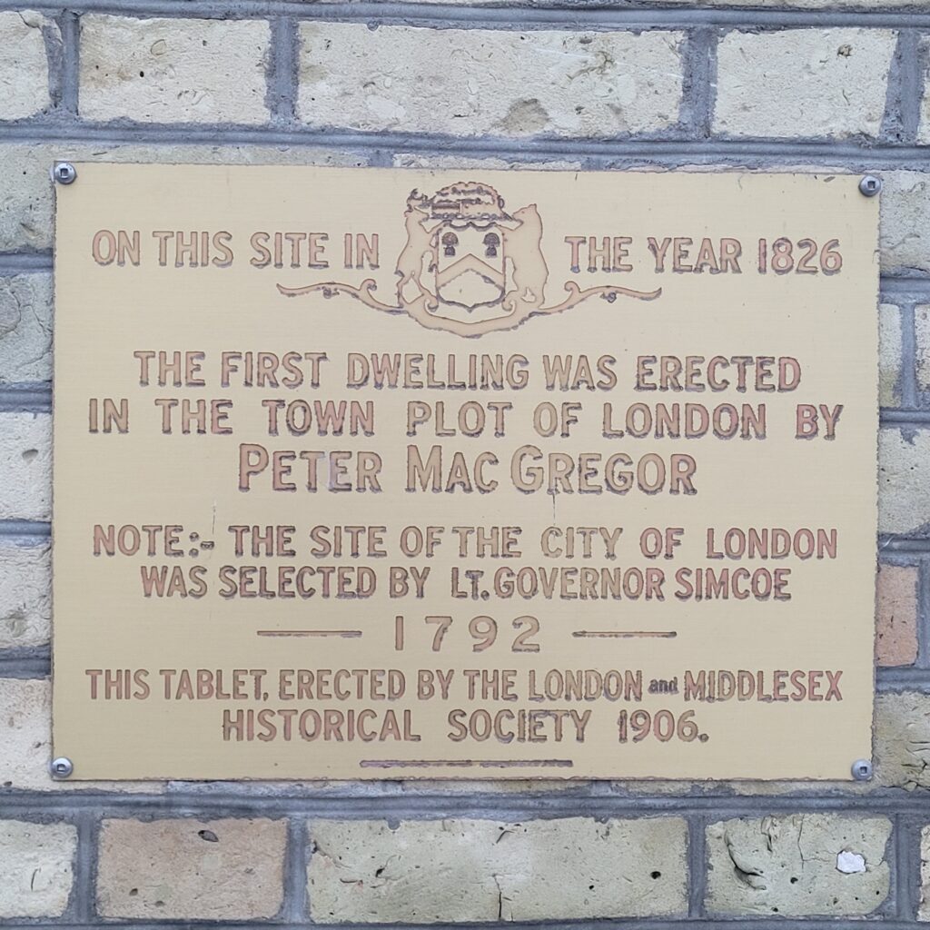 Historical Plaque reading: On this site in the year 1826, the first dwelling was erected in the town plot of London by Peter MacGregor. Note: The site of the city of London was selected by Lt. Governor Simcoe - 1792 - This tablet, erected by the London and Middlesex Historical Society 1906.