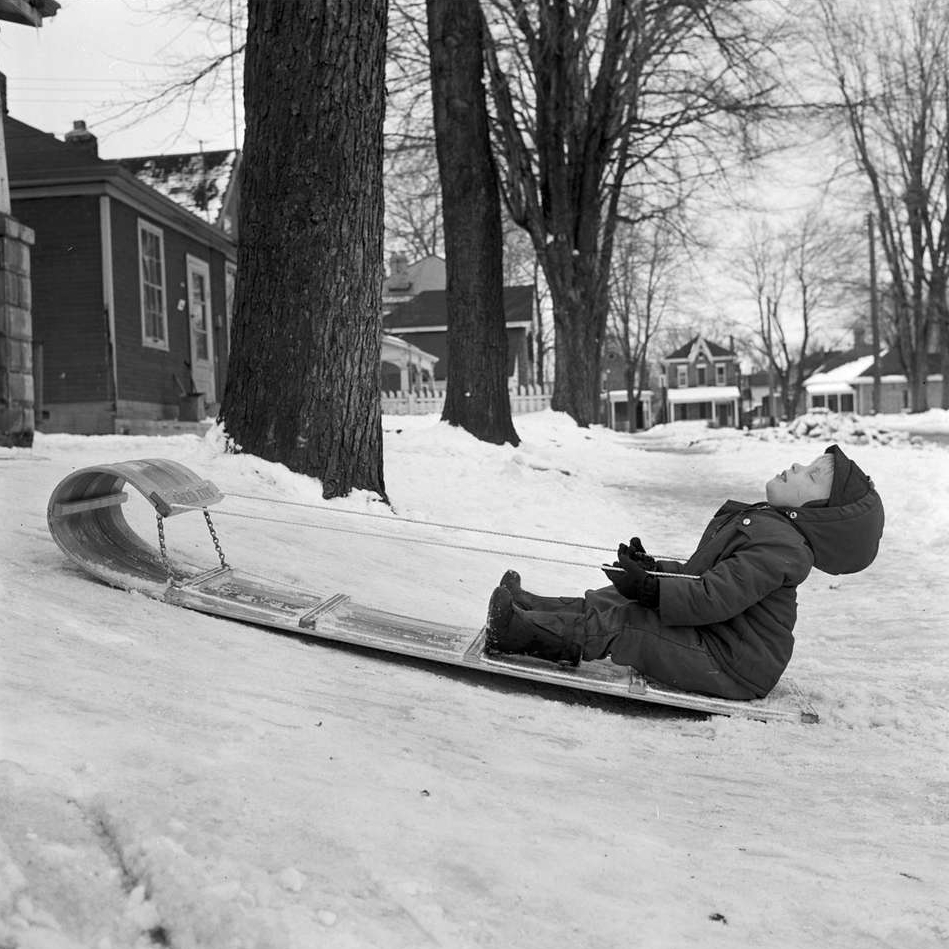 A five-year-old asleep on a toboggan after a long day. 
