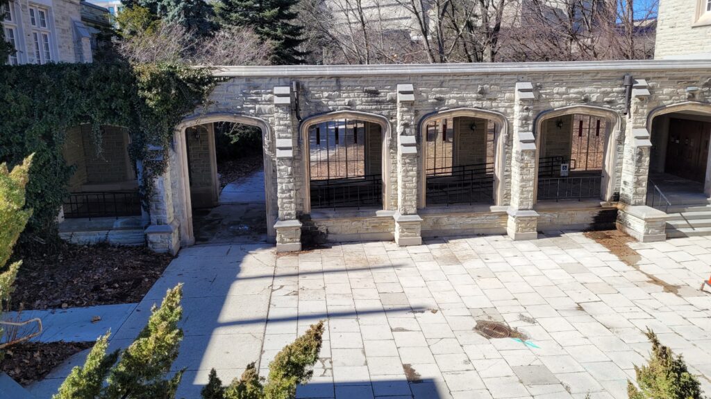 A quiet covered walkway, known as a cloister, connects two buildings on campus. 
