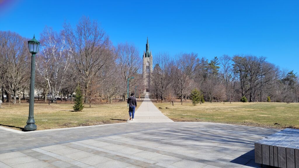 A student walking to Middlesex College, seen in the distance.