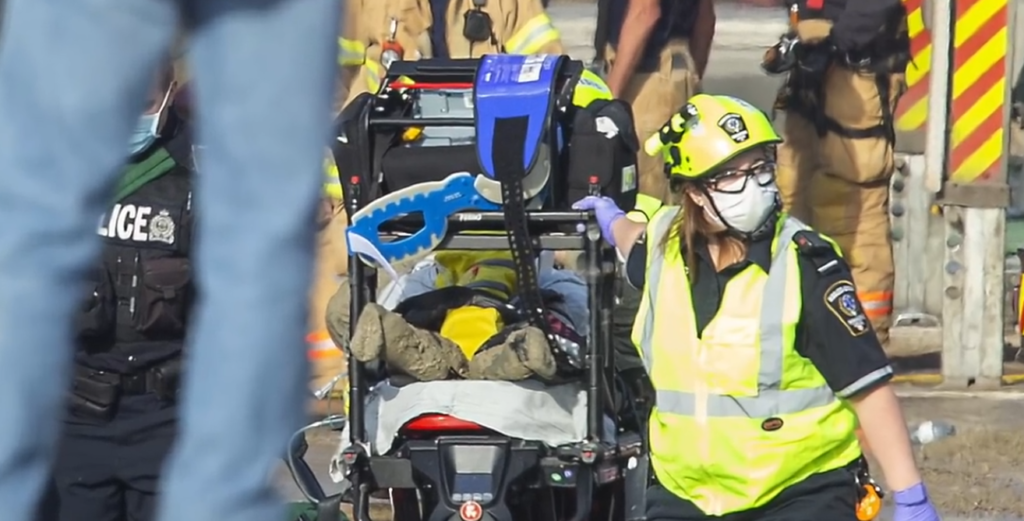 Injured worker being transported to the hospital by paramedics from the site of a building collapse.