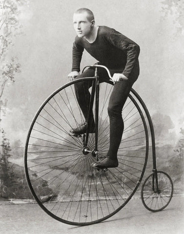 Man on an old high wheeler bicycle in 1880s.