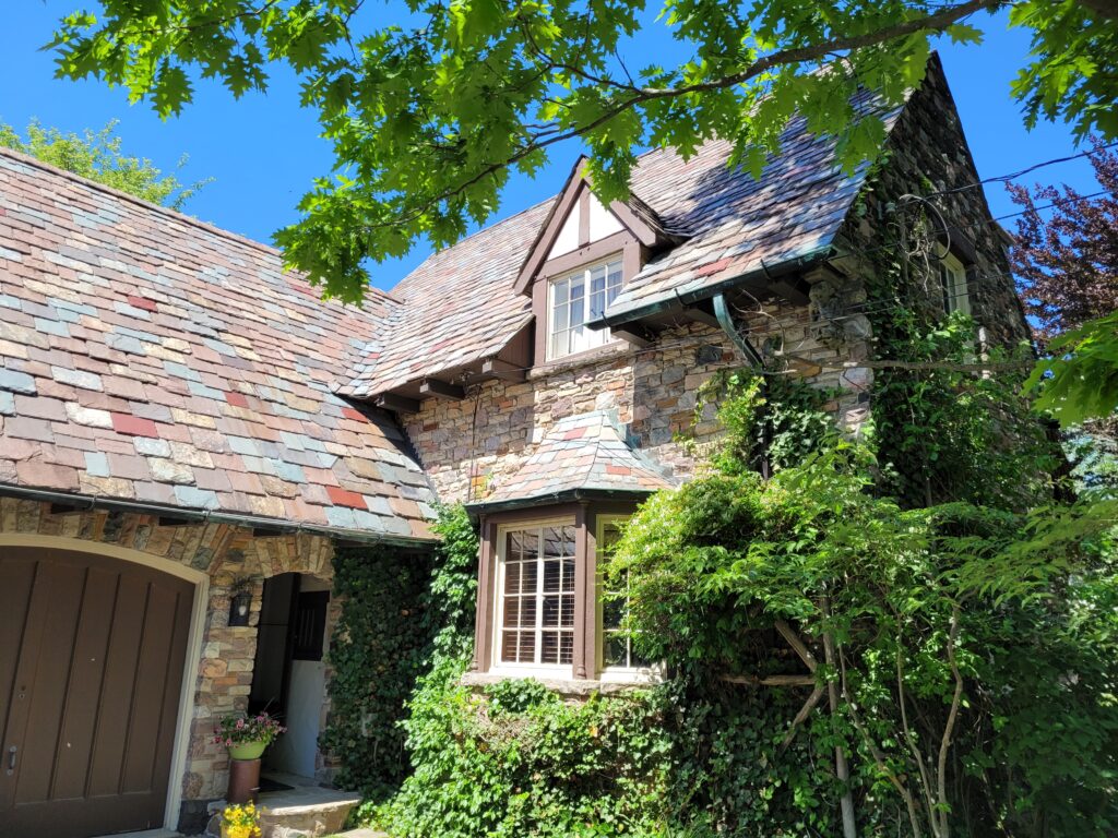 Note the delicate Tudor Arch over the doorway, and multicoloured slate roof.