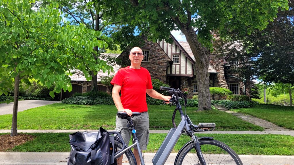 The author, with his bicycle, standing in front of the heritage home.