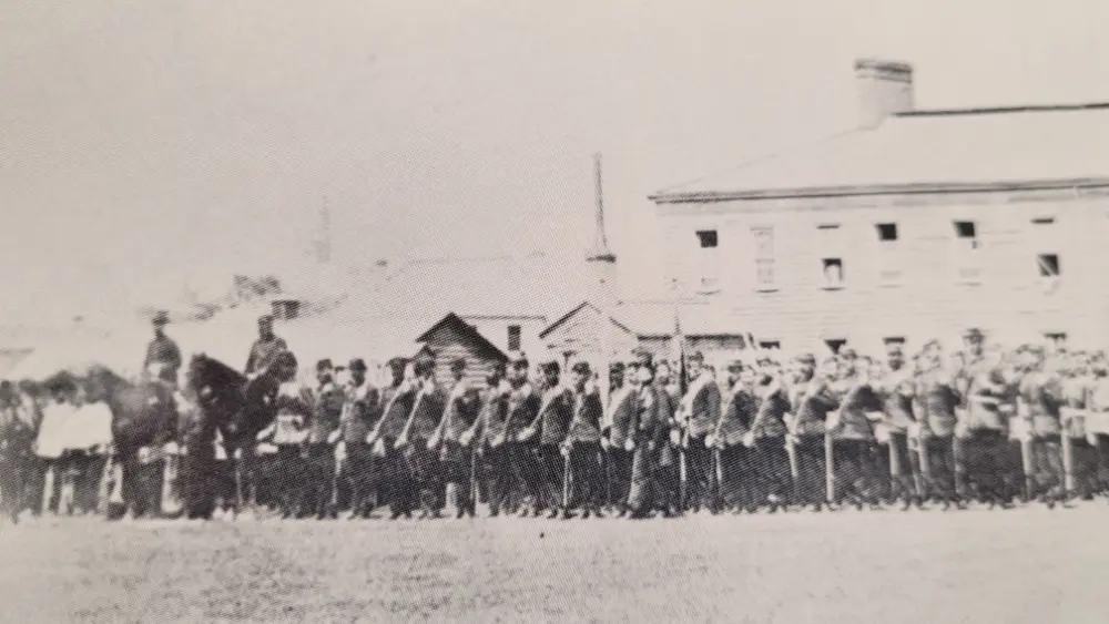 1866 photo of the 7th Fusiliers standing at attention in the parade grounds of the military compound.