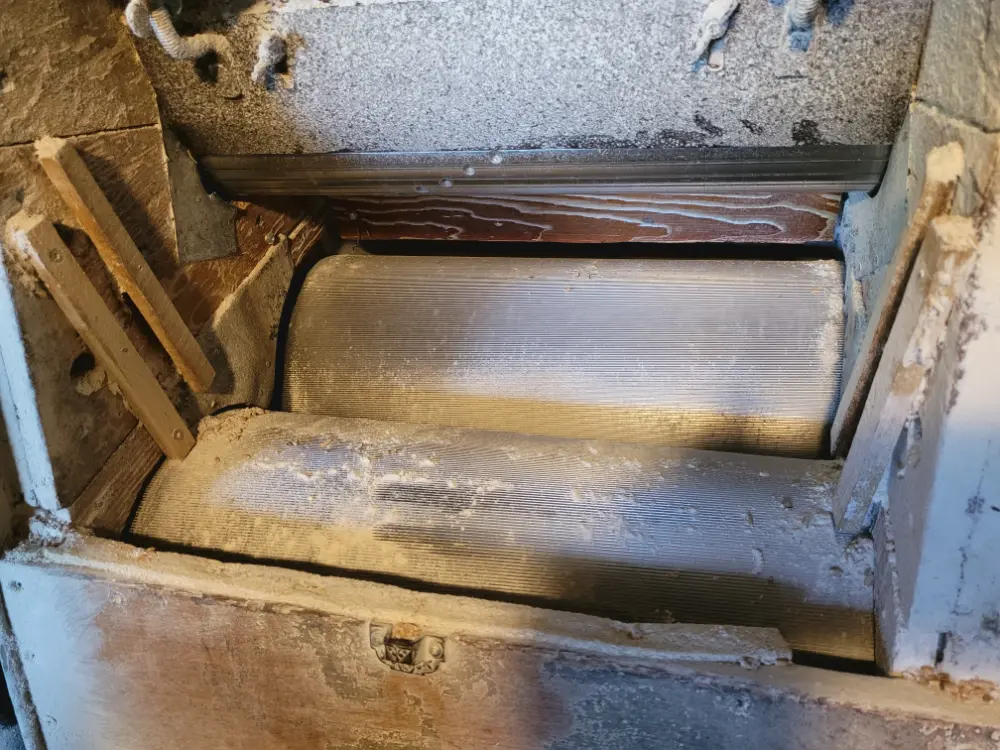 Rollers inside antique milling machine.