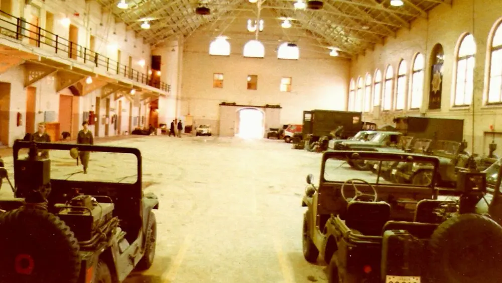 The atrium, as it was pre-renovation, showing army jeeps, cars, military trucks, and military personnel.