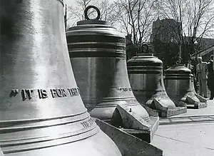 A line up of huge church bells, gradually descending in size.