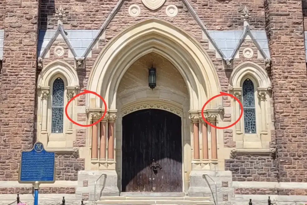 Carved heads of two bishops appear on either side of the front door.