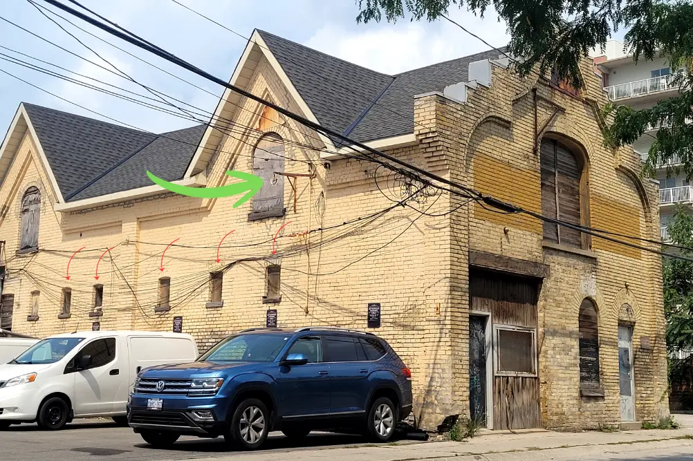 Old livery stable on Marshall Street with slit windows for light and ventilation for the horses and an upper floor loading window for hay.