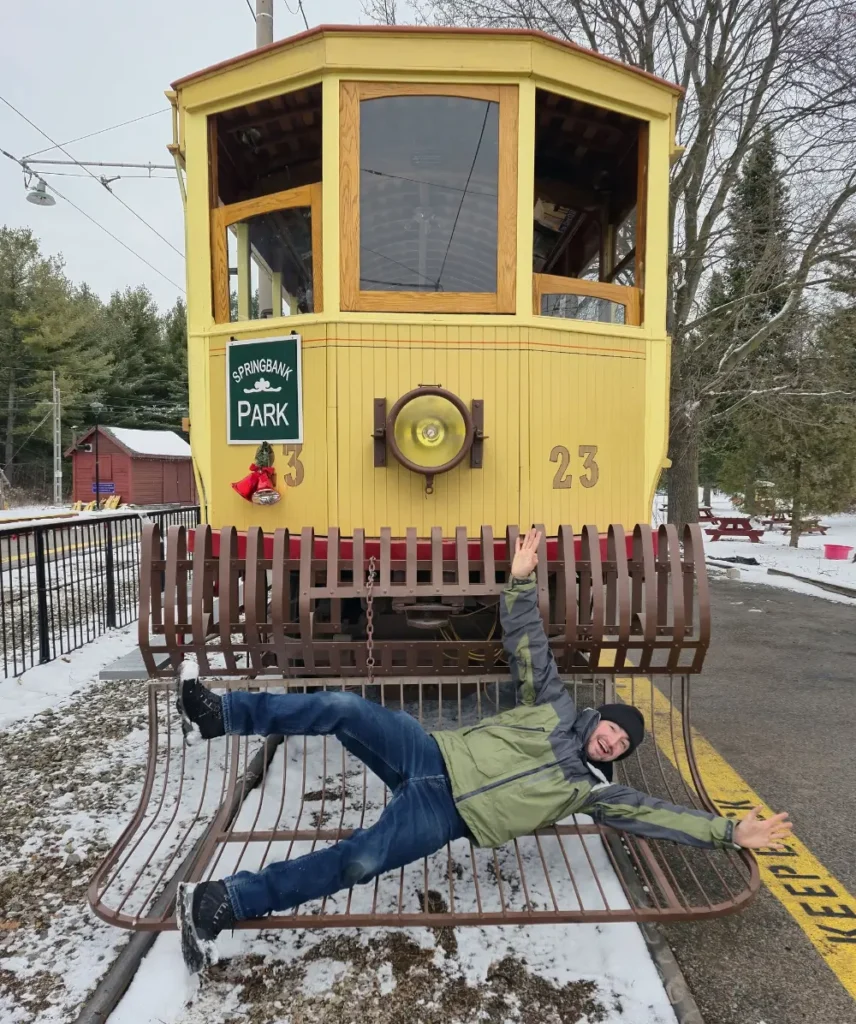 An enthusiastic volunteer lying down in front of the streetcar on the "people catcher." 
