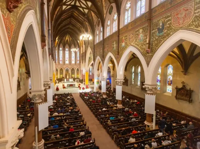 Interior view of St Peter's with many people in attendance.