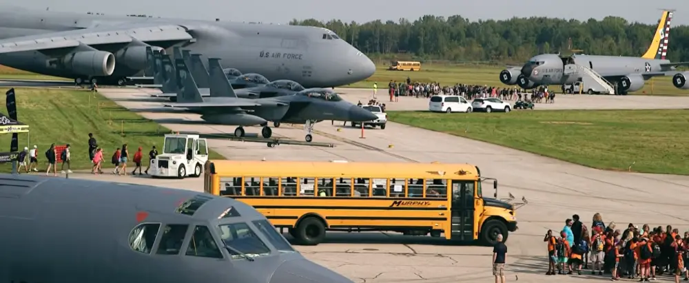 School bus shuttles people to the tarmac to see static displays of aircraft.