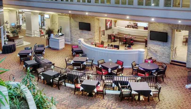 View of the Armouries Grille and Front Lobby from the Cantata Lounge, showing curved walls and dining areas.