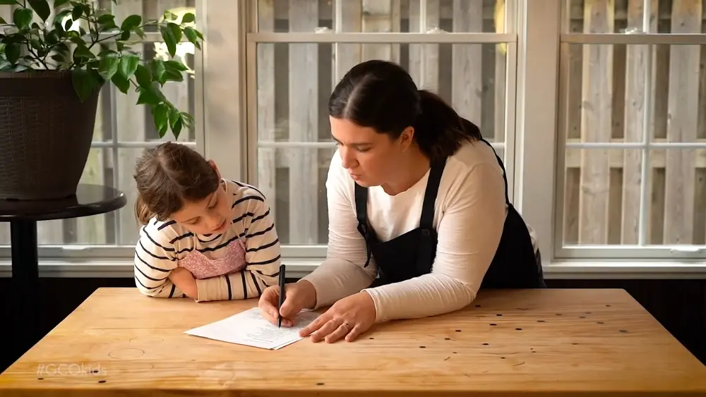 Executive Chef Katherine Jones, teaching a student how to plan a meal using a recipe.