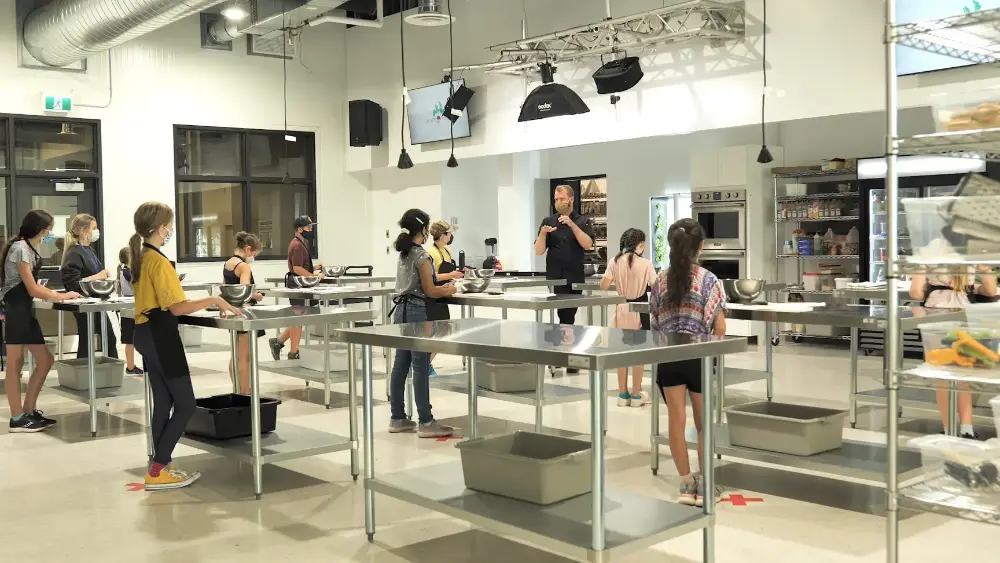 10-year old children being taught by a chef in a commercial grade teaching kitchen.