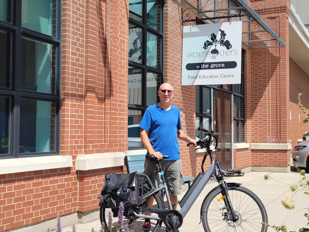 Author, Lawrence Durham, standing in front of the Growing Chefs! Education Centre in the Grove with his bicycle.