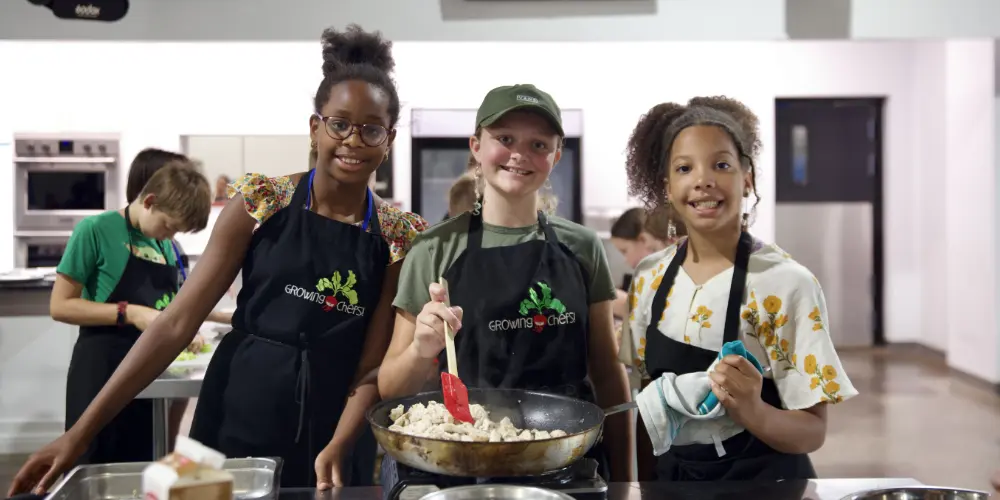 Teens proudly displaying their latest culinary creations.