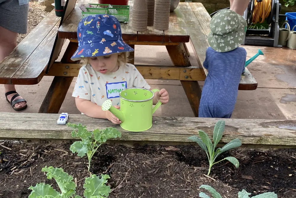 Young children watering plants.